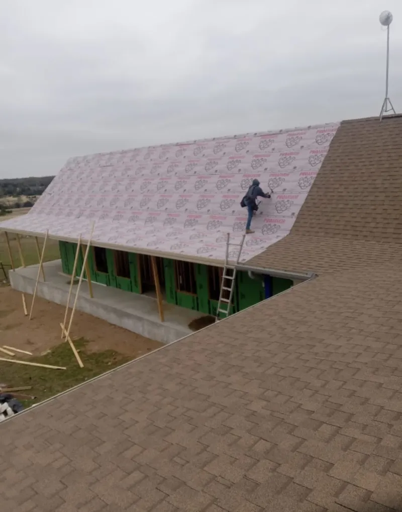 Worker preparing underlayment for a metal roof installation in Pullman